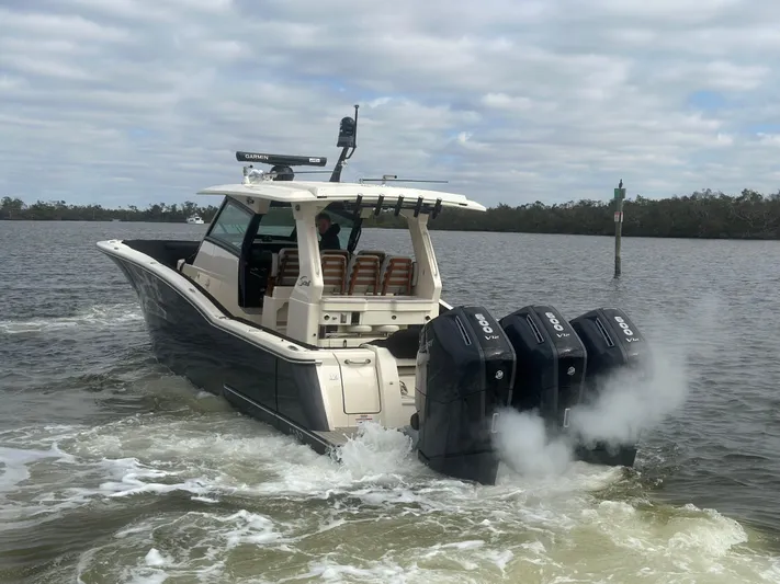  Yacht Photos Pics 2023 Scout 425 LXF boat cruising on a lake with triple engines.