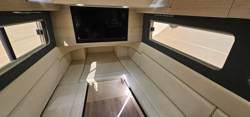 Yacht Photos Pics Luxurious interior of 2023 Scout 425 LXF boat with beige seating and large TV.