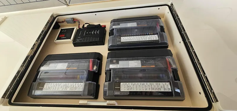  Yacht Photos Pics 2023 Scout 425 LXF boat battery compartment with four batteries and control panel.