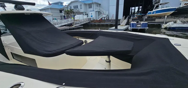  Yacht Photos Pics 2023 Scout 425 LXF boat with black seating covers at a marina.
