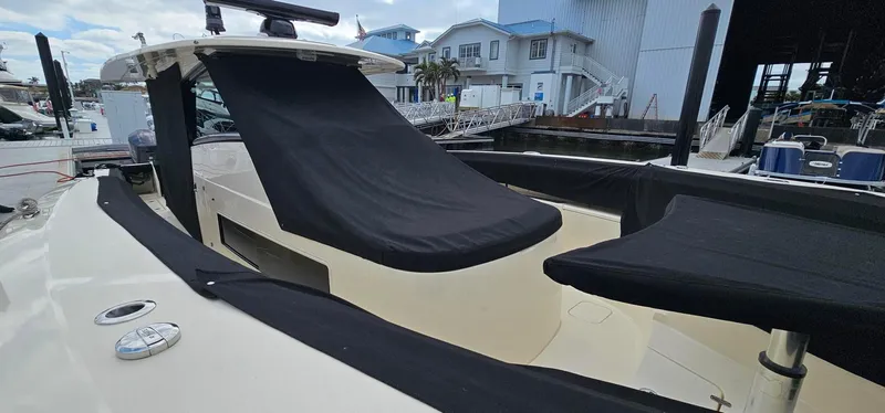  Yacht Photos Pics 2023 Scout 425 LXF boat with black covers at a marina.