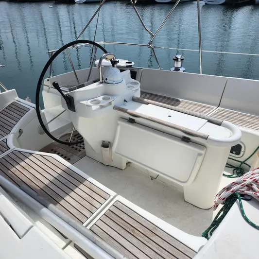 Scot-free Yacht Photos Pics Cockpit of 1999 Beneteau Oceanis 461 sailboat with wooden seating and steering wheel.