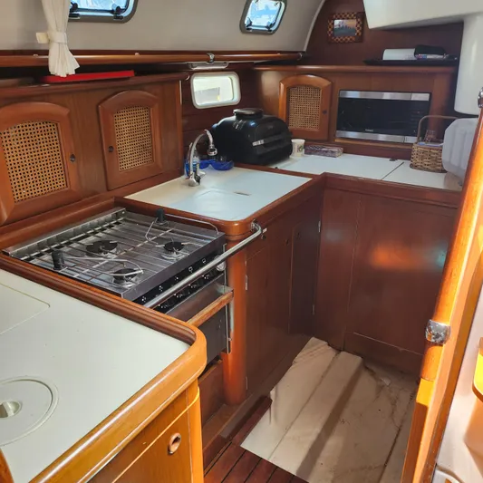Scot-free Yacht Photos Pics 1999 Beneteau Oceanis 461 yacht kitchen with wooden cabinetry and modern appliances.