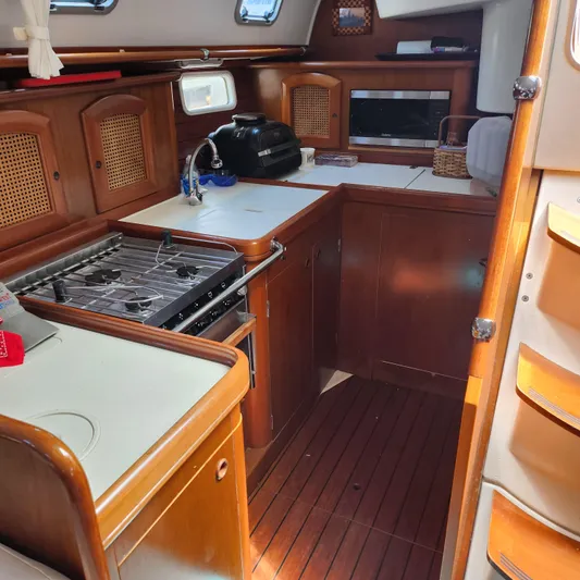 Scot-free Yacht Photos Pics Interior of 1999 Beneteau Oceanis 461 yacht kitchen with wood cabinetry and appliances.