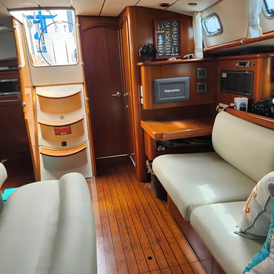 Scot-free Yacht Photos Pics Interior of 1999 Beneteau Oceanis 461 sailboat with wood flooring and cozy seating area.