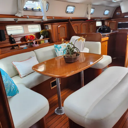 Scot-free Yacht Photos Pics Interior of 1999 Beneteau Oceanis 461 yacht with elegant dining area and wooden finishes.