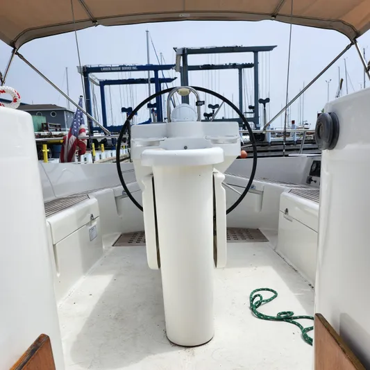 Scot-free Yacht Photos Pics Cockpit of 1999 Beneteau Oceanis 461 sailboat with steering wheel and marina view.