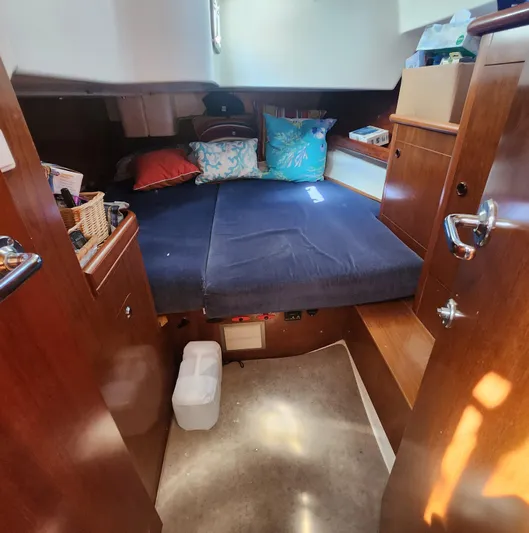 Scot-free Yacht Photos Pics Cozy cabin interior of 1999 Beneteau Oceanis 461 sailboat with bed and wooden storage.