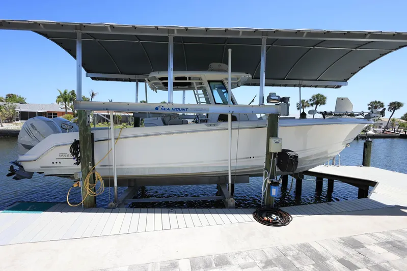  Yacht Photos Pics 2019 Boston Whaler 330 Outrage boat docked under a canopy on a sunny day.