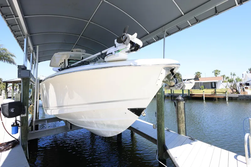  Yacht Photos Pics 2019 Boston Whaler 330 Outrage boat docked under a canopy on a sunny day.