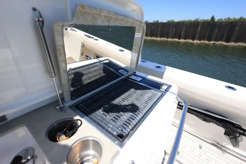  Yacht Photos Pics 2019 Boston Whaler 330 Outrage boat with outdoor grill and sink setup.