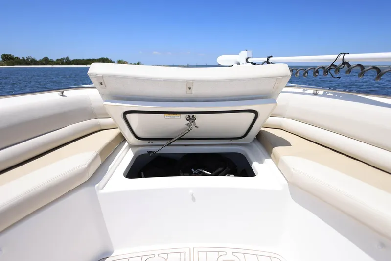  Yacht Photos Pics 2019 Boston Whaler 330 Outrage boat with open storage compartment, beige seating, and ocean backdrop.