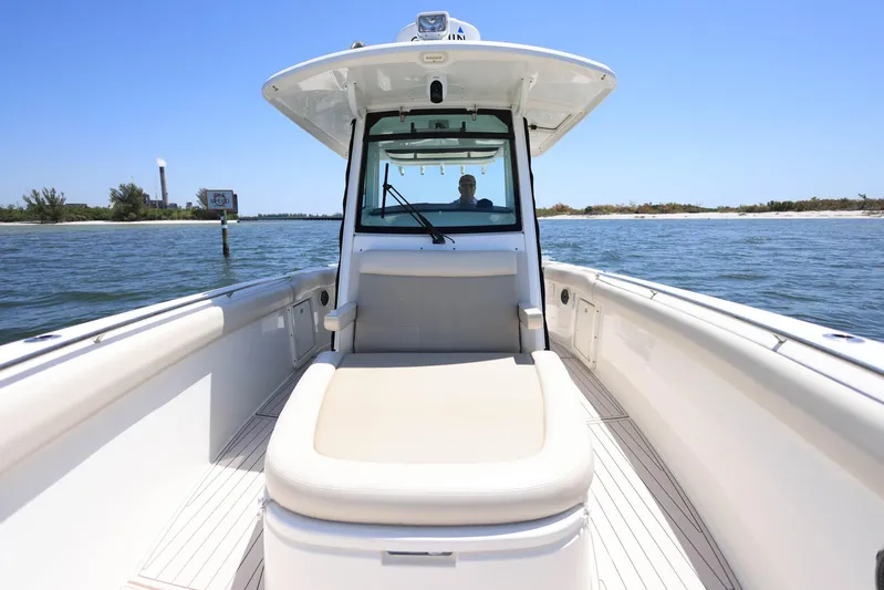  Yacht Photos Pics 2019 Boston Whaler 330 Outrage boat on water, featuring spacious deck and seating.