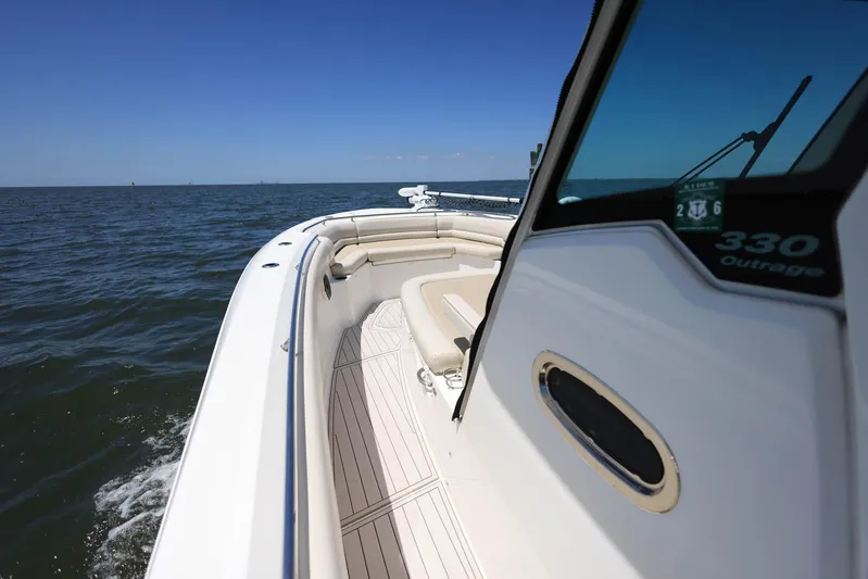  Yacht Photos Pics 2019 Boston Whaler 330 Outrage cruising on open water under clear blue skies.