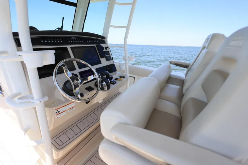 Yacht Photos Pics 2019 Boston Whaler 330 Outrage helm with steering wheel and controls, overlooking the ocean.