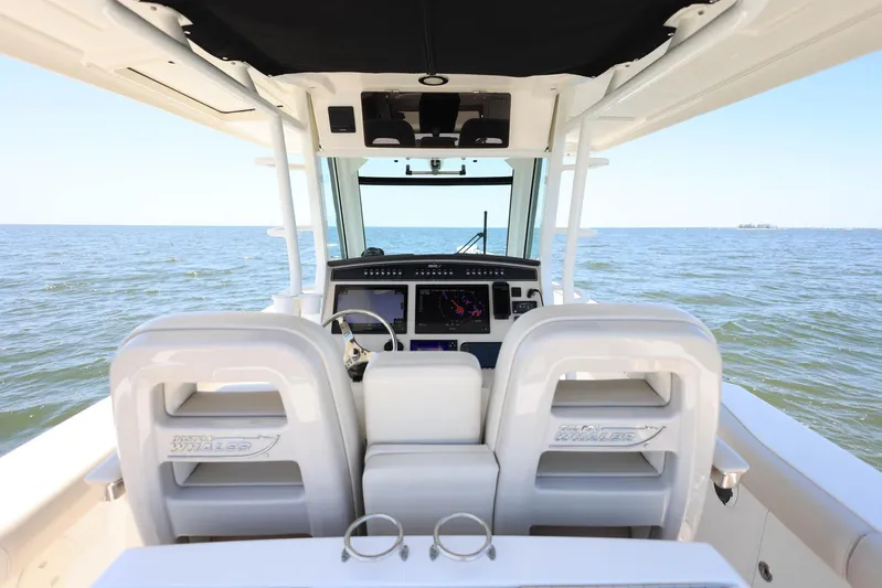  Yacht Photos Pics 2019 Boston Whaler 330 Outrage boat interior with ocean view, featuring helm and seating.