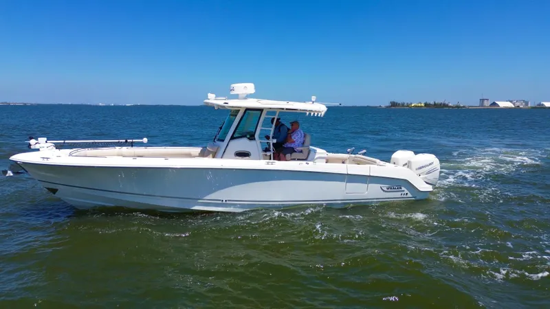  Yacht Photos Pics 2019 Boston Whaler 330 Outrage cruising on open water under clear blue skies.