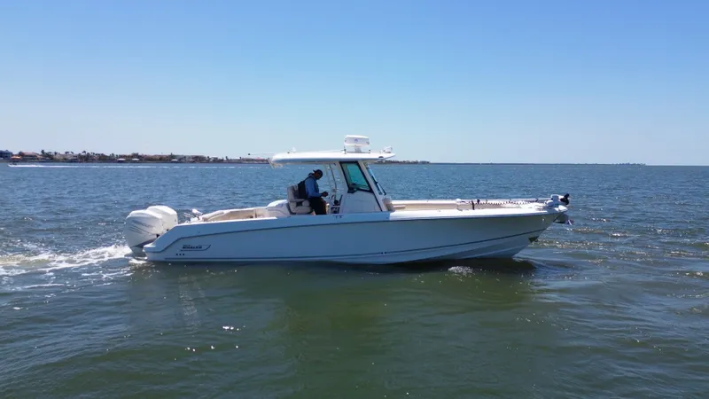  Yacht Photos Pics 2019 Boston Whaler 330 Outrage cruising on open water under clear blue skies.