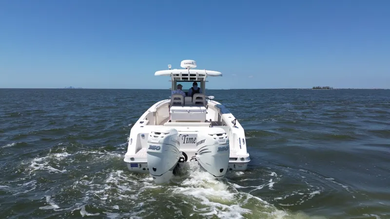  Yacht Photos Pics 2019 Boston Whaler 330 Outrage cruising on open water, rear view.