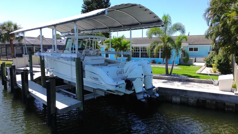  Yacht Photos Pics 2019 Boston Whaler 330 Outrage on a lift by waterfront home.