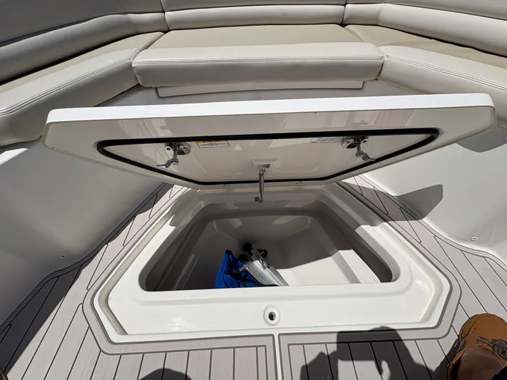  Yacht Photos Pics 2019 Boston Whaler 330 Outrage storage compartment with open hatch and cushioned seating.