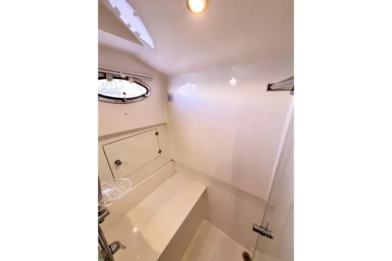 American Girl Yacht Photos Pics 2021 Back Cove 390 yacht interior, featuring a compact, modern bathroom with a porthole window.