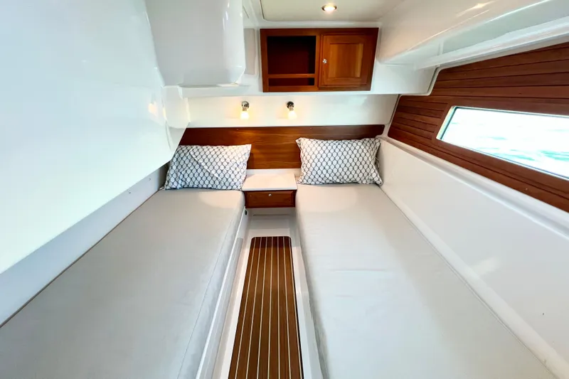 American Girl Yacht Photos Pics 2021 Back Cove 390 cabin interior with twin beds, wooden accents, and modern lighting.