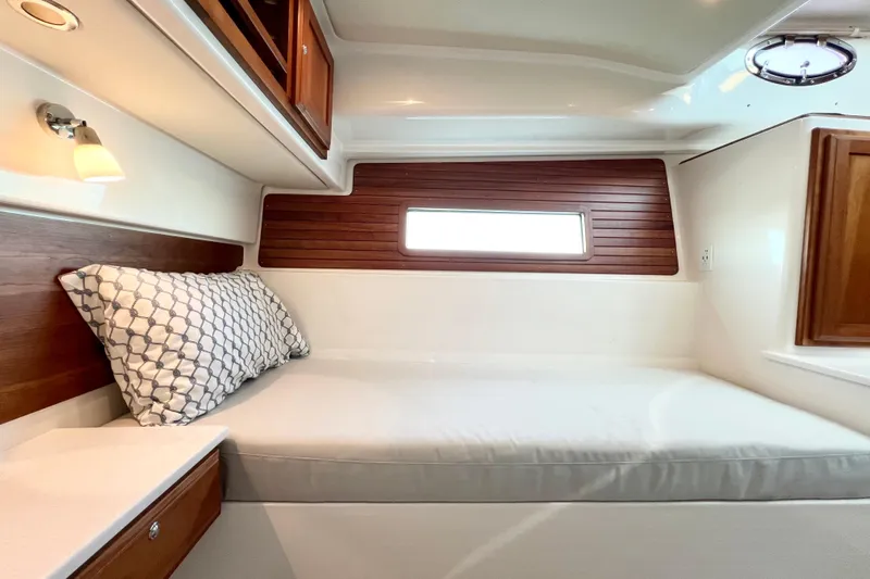 American Girl Yacht Photos Pics 2021 Back Cove 390 interior cabin with wooden accents and cozy bedding.