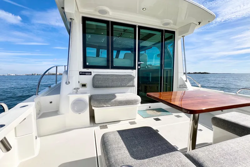 American Girl Yacht Photos Pics 2021 Back Cove 390 yacht with outdoor seating and table, overlooking the ocean.