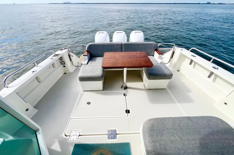 American Girl Yacht Photos Pics 2021 Back Cove 390 boat deck with seating and table, overlooking calm waters.