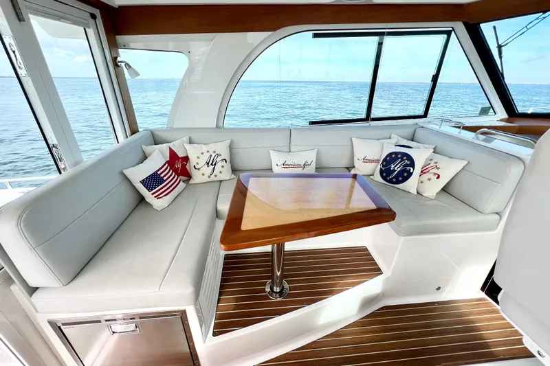 American Girl Yacht Photos Pics 2021 Back Cove 390 yacht interior with cushioned seating and decorative pillows.