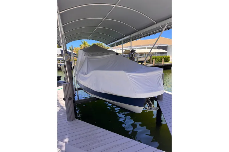  Yacht Photos Pics Covered 2021 Nimbus T9 boat docked under a canopy.