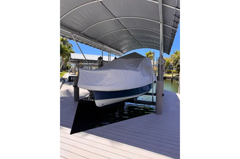  Yacht Photos Pics Covered 2021 Nimbus T9 boat on a dock under a canopy.