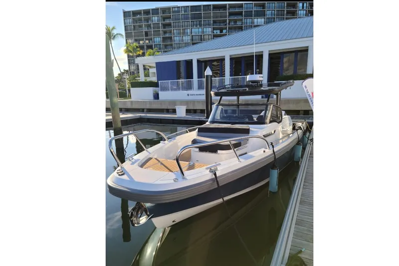  Yacht Photos Pics 2021 Nimbus T9 boat docked at marina with modern building backdrop.