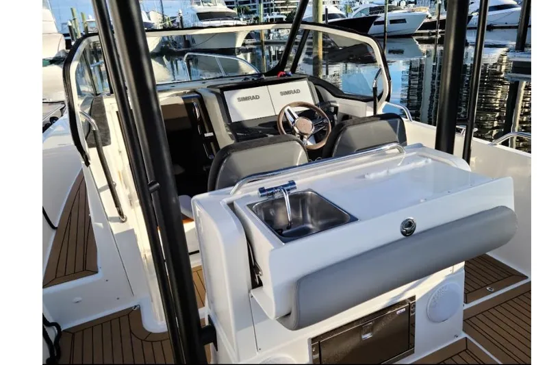  Yacht Photos Pics 2021 Nimbus T9 boat interior with steering wheel, sink, and modern dashboard at marina.