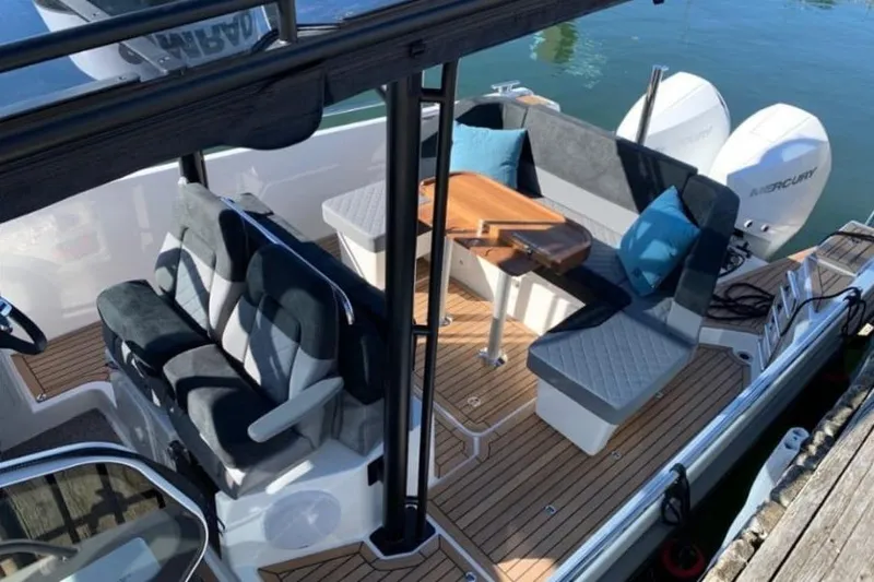  Yacht Photos Pics 2021 Nimbus T9 boat interior with seating, table, and Mercury engines.
