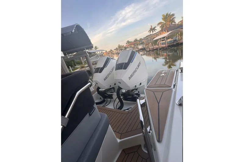  Yacht Photos Pics 2021 Nimbus T9 boat with dual Mercury outboard engines docked by a scenic waterfront.