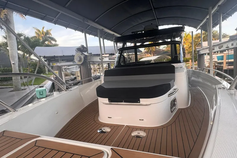  Yacht Photos Pics 2021 Nimbus T9 boat with sleek design, wooden deck, and comfortable seating under a canopy.