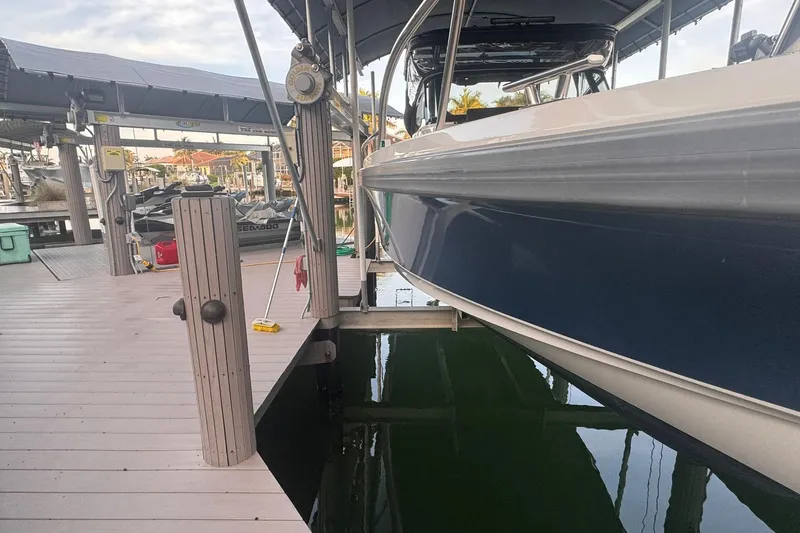  Yacht Photos Pics Docked Nimbus T9 boat from 2021, with a sleek blue hull, at a marina.