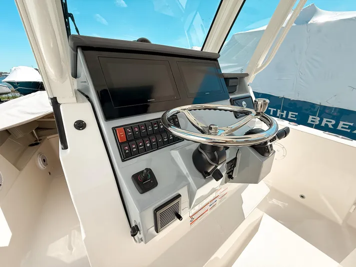  Yacht Photos Pics 2024 Pursuit S 288 Sport boat dashboard with steering wheel and control panel.