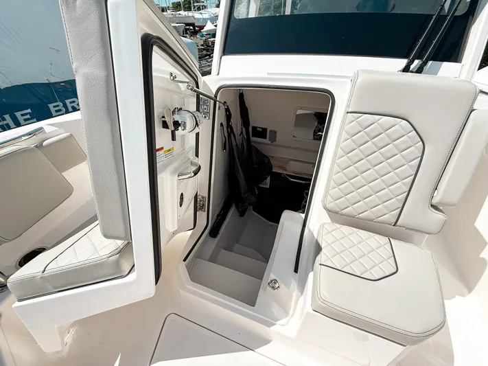  Yacht Photos Pics 2024 Pursuit S 288 Sport boat interior with open storage compartment and cushioned seating.