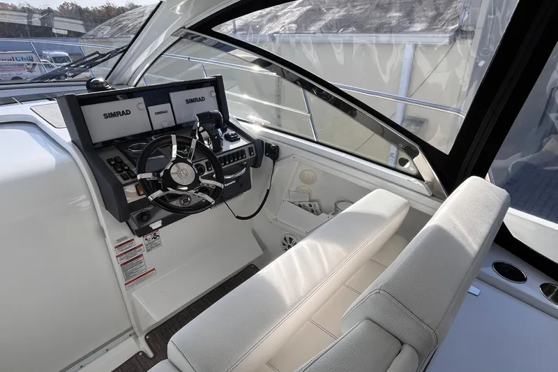  Yacht Photos Pics 2018 Cruisers Yachts 390 Express Coupe helm with Simrad navigation system and white seating.