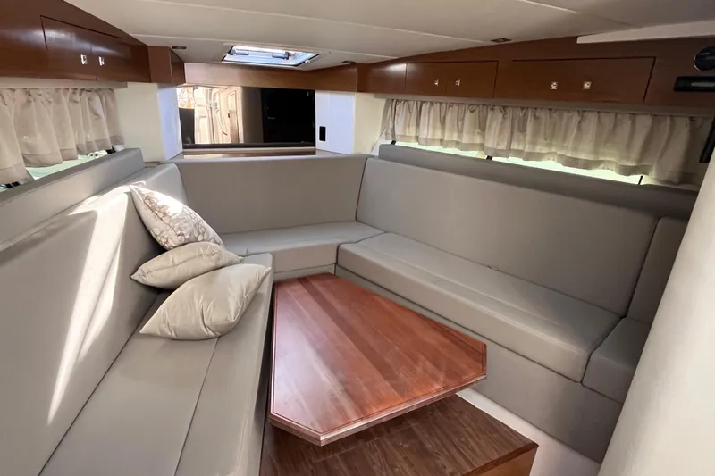  Yacht Photos Pics Luxurious interior of 2018 Cruisers Yachts 390 Express Coupe with plush seating and wooden table.