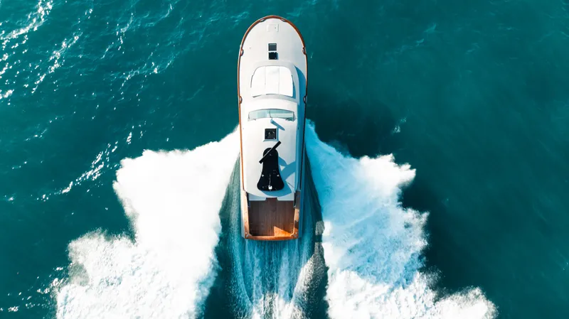  Yacht Photos Pics Aerial view of 2025 Buddy Davis 52 Express yacht cruising on blue ocean waters.