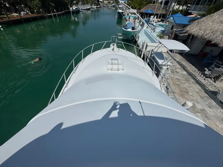  Yacht Photos Pics 2005 Ocean Yachts 50 Super Sport docked in a serene canal setting.