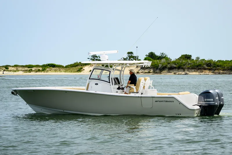  Yacht Photos Pics 2018 Sportsman Open 312 Center Console boat cruising on calm waters near a scenic shoreline.