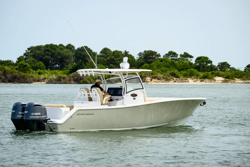  Yacht Photos Pics 2018 Sportsman Open 312 Center Console boat cruising on water near a forested shoreline.