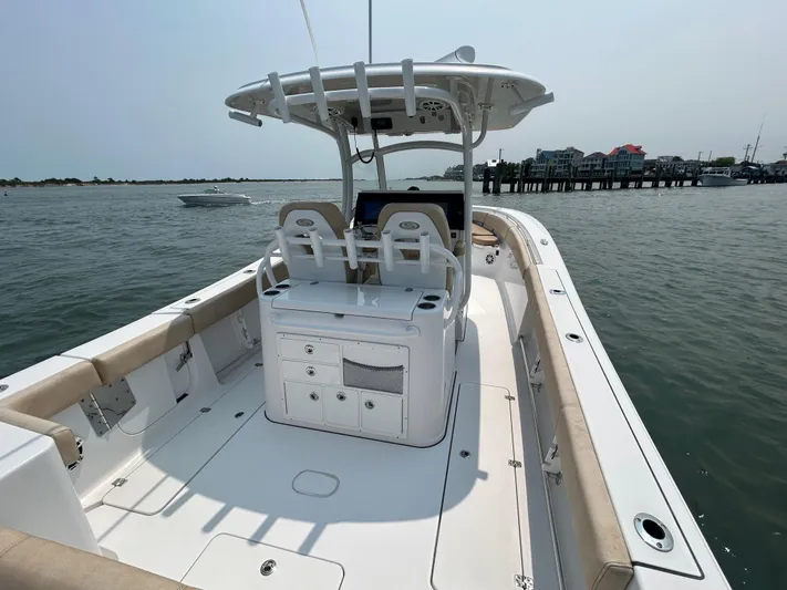  Yacht Photos Pics 2018 Sportsman Open 312 Center Console boat on calm water near a dock.