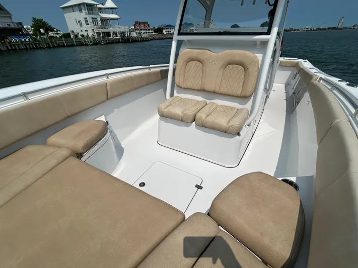  Yacht Photos Pics 2018 Sportsman Open 312 Center Console boat with beige seating, docked by waterfront homes.