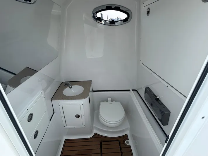  Yacht Photos Pics 2018 Sportsman Open 312 Center Console boat bathroom with sink, toilet, and wooden floor.
